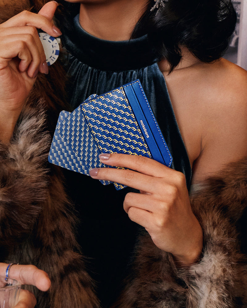 Woman in a fur stole holding a navy Stash Card Sleeve
