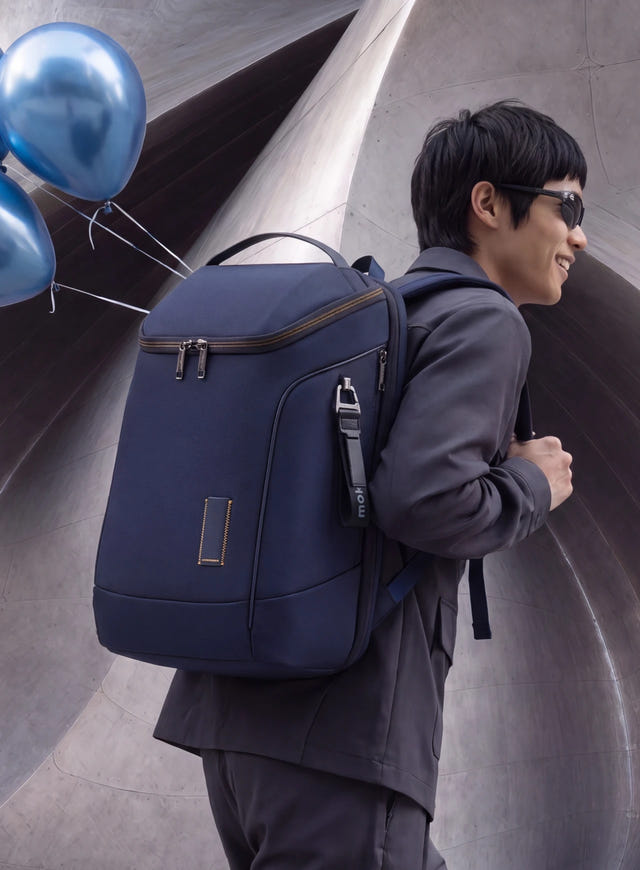 A navy Transit Z backpack worn past a steel sculpture and blue balloons